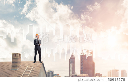 Engineer man standing on roof and looking away. Mixed media 30918276