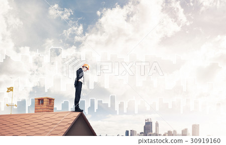 Engineer man standing on roof and looking down. Mixed media 30919160