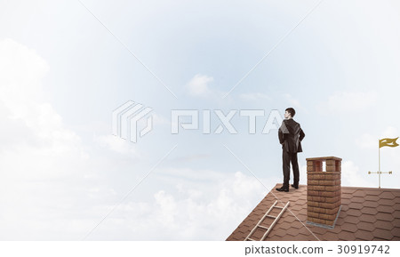 Mister boss on brick roof with arms akimbo. Mixed media Mister boss on brick roof with arms akimbo. Mixed media 30919742