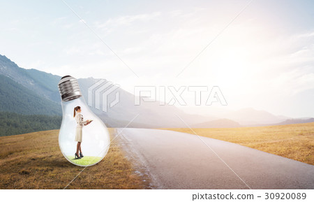 Businesswoman inside light bulb Businesswoman inside light bulb 30920089