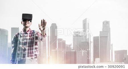 Guy wearing checked shirt and virtual mask stretching hand to touch something Guy wearing checked shirt and virtual mask stretching hand to touch something 30920091