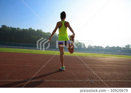 woman runner stretching before run   30920679