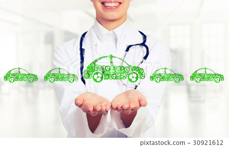 Close up of female hand showing car symbol made with gears and cogwheels Close up of female hand showing car symbol made with gears and cogwheels 30921612