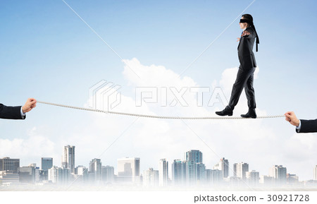 Business concept of risk support and assistance with man balancing on rope Business concept of risk support and assistance with man balancing on rope 30921728