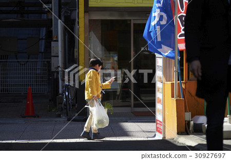 A boy walking in an obscurating shopping area 30927697