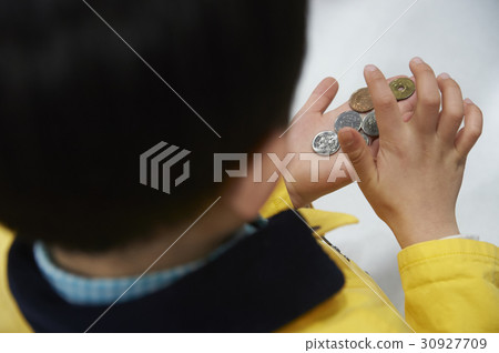 A boy counting tight coins A boy counting tight coins 30927709