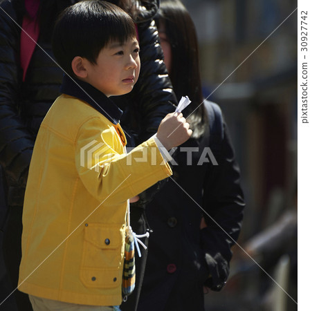 A boy walking in an obscurating shopping area 30927742