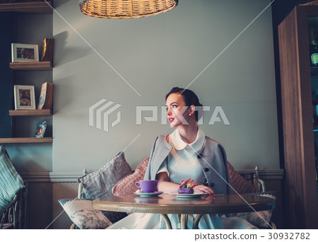 Elegant young lady alone in a cafe Elegant young lady alone in a cafe 30932782