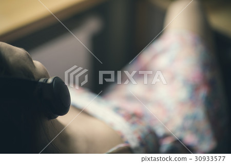 Girl in headphones by the window 30933577