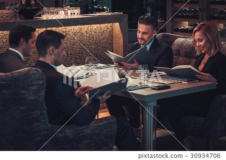 Friends rading menu in a restaurant. Friends rading menu in a restaurant. 30934706