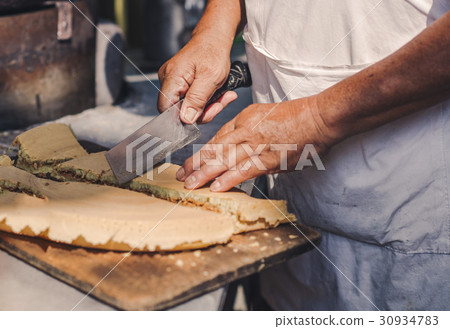 A man is cooking a pie in the market of chinatown, A man is cooking a pie in the market of chinatown, 30934783