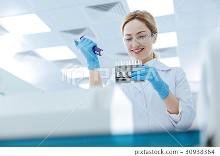 Positive young woman working chemical laboratory Positive young woman working chemical laboratory 30938364