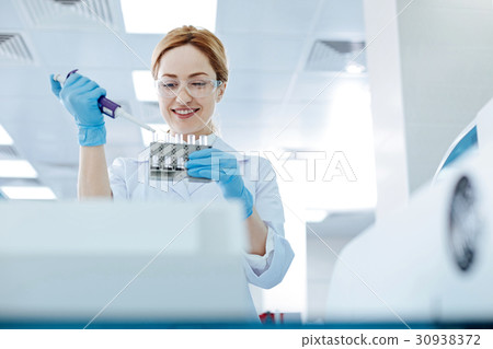 Positive delighted blonde lab assistant pouring 30938372