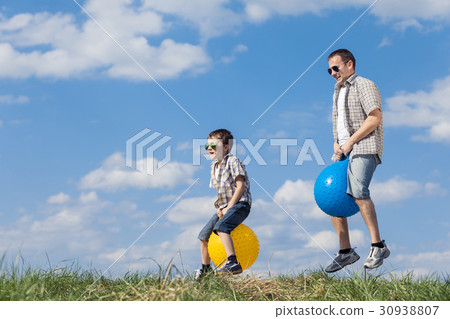 Father and son playing on the field at the day time. 30938807