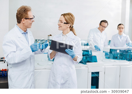 Positive delighted female scientist holding tablet Positive delighted female scientist holding tablet 30939047