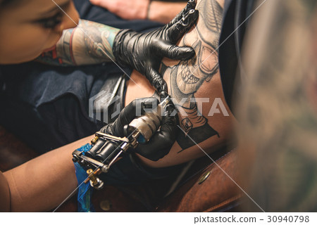 Female doing tattoo on belly of man Female doing tattoo on belly of man 30940798