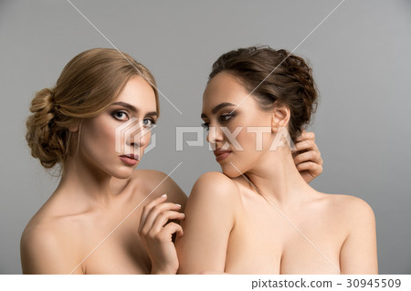 Two models topless posing together in studio 30945509