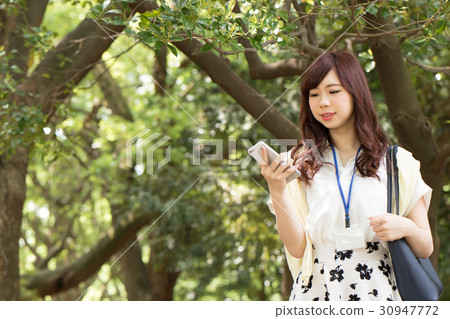 Business woman who operates a smartphone 30947772