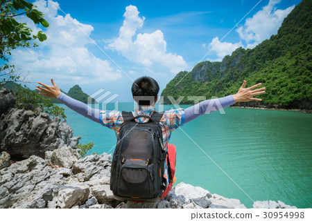 Happy backpacker man sitting enjoy with rise arm Happy backpacker man sitting enjoy with rise arm 30954998