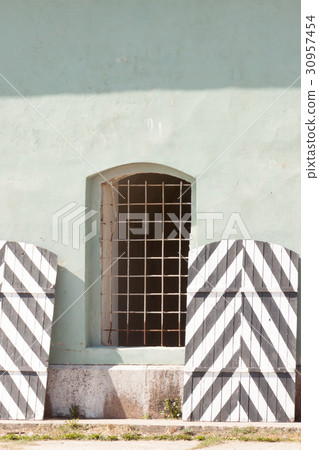 wall of prison with barred windows 30957454