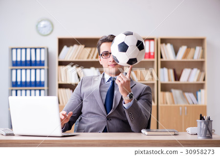 Businessman with football ball in office 30958273