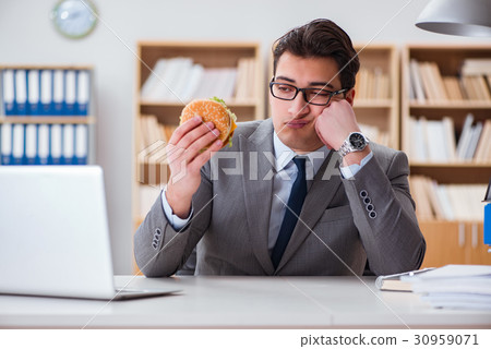 Hungry funny businessman eating junk food sandwich 30959071