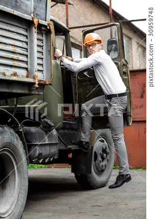 Engineer builder in a helmet holds drawings at 30959748