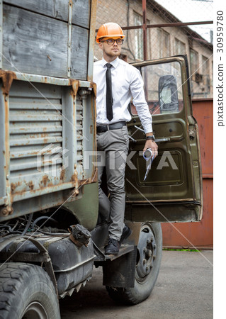 Engineer builder in a helmet directs construction  30959780