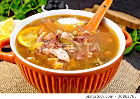 Solyanka with lemon and spoon in bowl on board 30962765