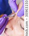 Cosmetic Surgeon Doctor Giving Botox to Woman Face 30963150