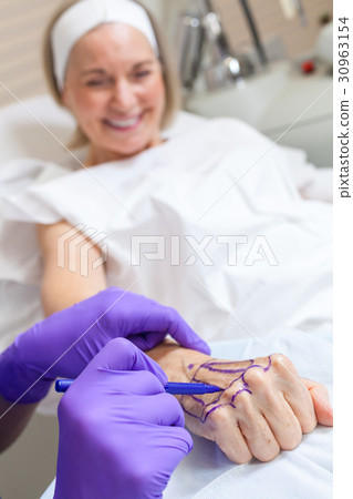 Plastic Surgeon Doctor Marks Hand of Senior Woman Plastic Surgeon Doctor Marks Hand of Senior Woman 30963154