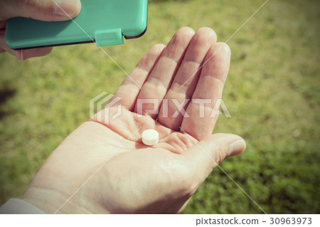 吃男性的片劑的男性手片劑 30963973