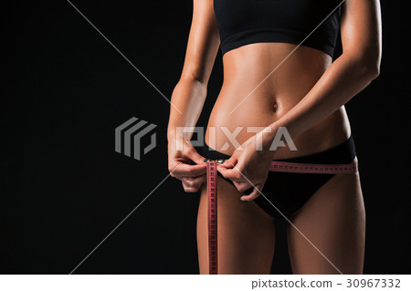 The fit woman measuring perfect shape of beautiful The fit woman measuring perfect shape of beautiful 30967332