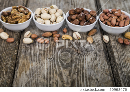 Nuts in a plate on a wooden table. Nuts in a plate on a wooden table. 30968476