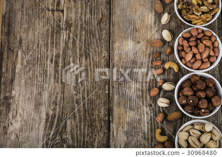 Nuts in a plate on a wooden table. Nuts in a plate on a wooden table. 30968480