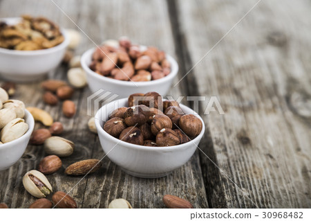 Nuts in a plate on a wooden table. Nuts in a plate on a wooden table. 30968482