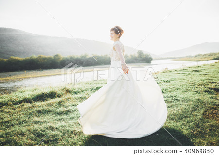 Bride in wedding dress posing on grass with Bride in wedding dress posing on grass with 30969830