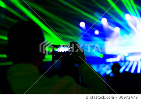 Man taking photo mobile phone of silhouettes crowd Man taking photo mobile phone of silhouettes crowd 30972479