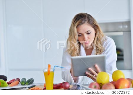 Smiling beautiful woman preparing salad at morning Smiling beautiful woman preparing salad at morning 30972572