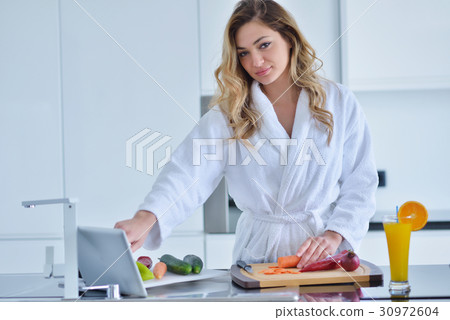 Smiling beautiful woman preparing salad at morning Smiling beautiful woman preparing salad at morning 30972604