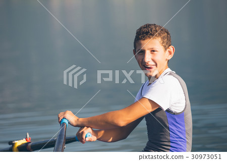 A Young single scull rowing competitor paddles on 30973051