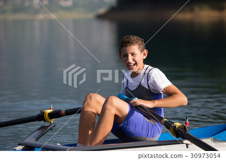 A Young single scull rowing competitor paddles on A Young single scull rowing competitor paddles on 30973054