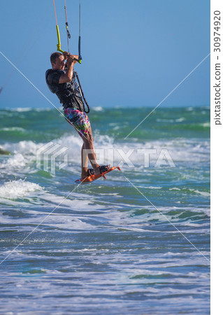 Young atletic man riding kite surf on a sea 30974920