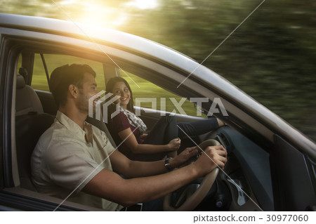 Happy young couple driving in car 30977060