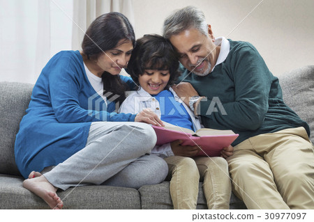 Grandson reading book to grandparents Grandson reading book to grandparents 30977097