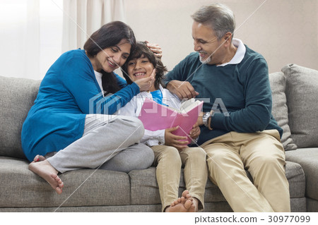 Grandson reading book to grandparents Grandson reading book to grandparents 30977099