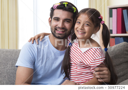 Portrait of funny father wearing hair clips with daughter Portrait of funny father wearing hair clips with daughter 30977224