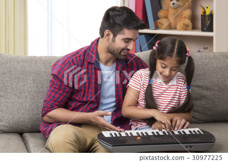 Father and daughter playing piano 30977225
