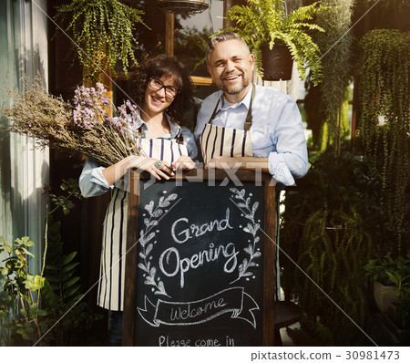 Adult Man and Woman Standing with Grand Opening Sign 30981473