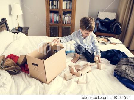 Little boy using imagination for wooden block to improve child d 30981591